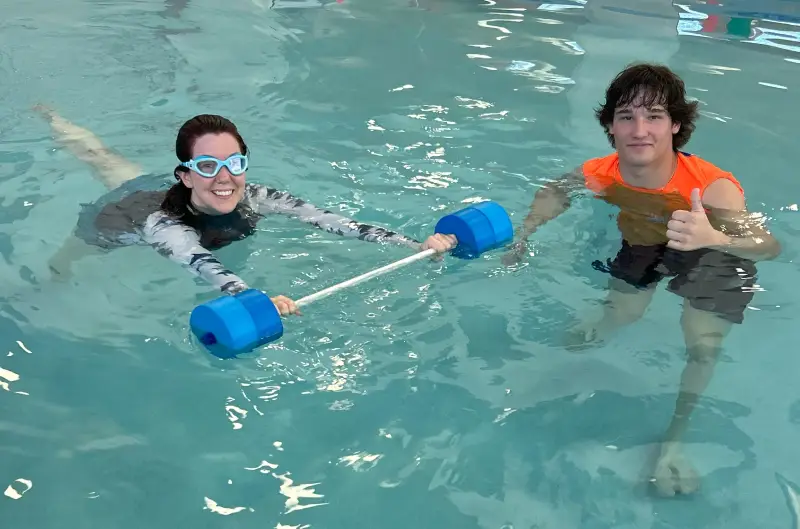 High angle view of cheerful trainers and senior swimmers in pool