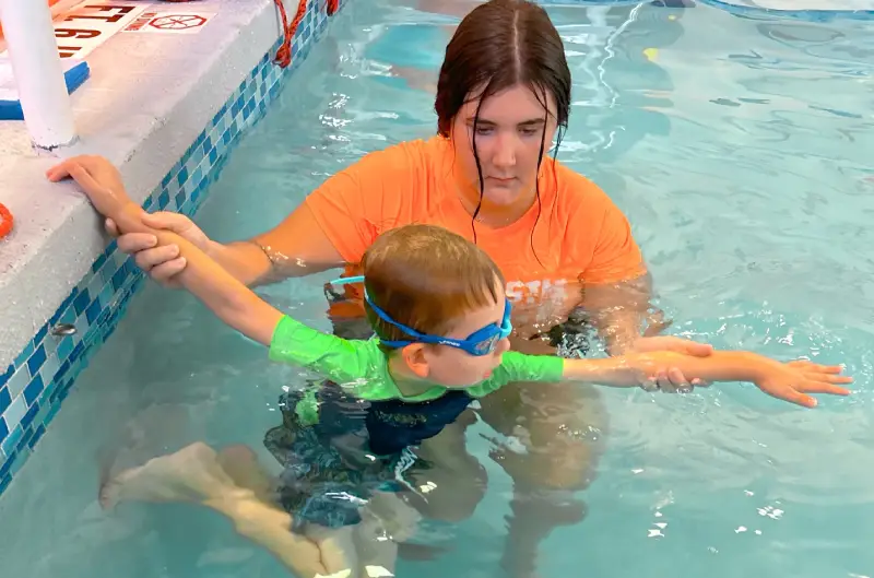 Boy on swimming class with instructor