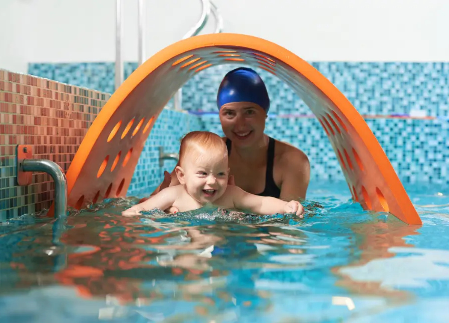 Baby boy dives underwater in the pool with pleasure
