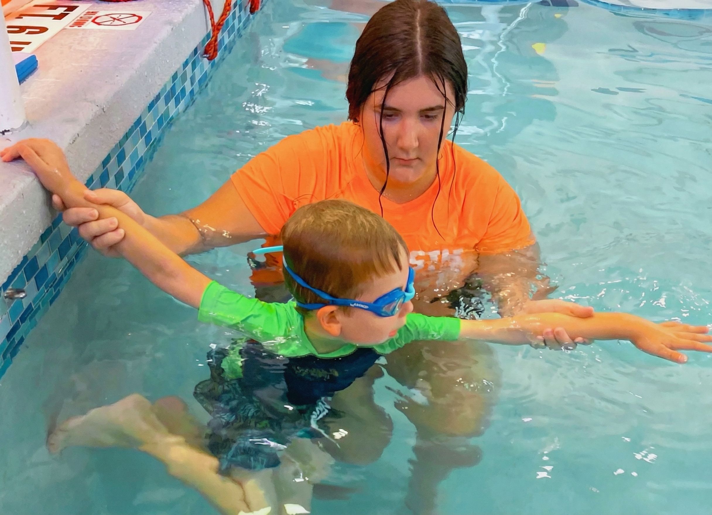 Boy on swimming class with instructor